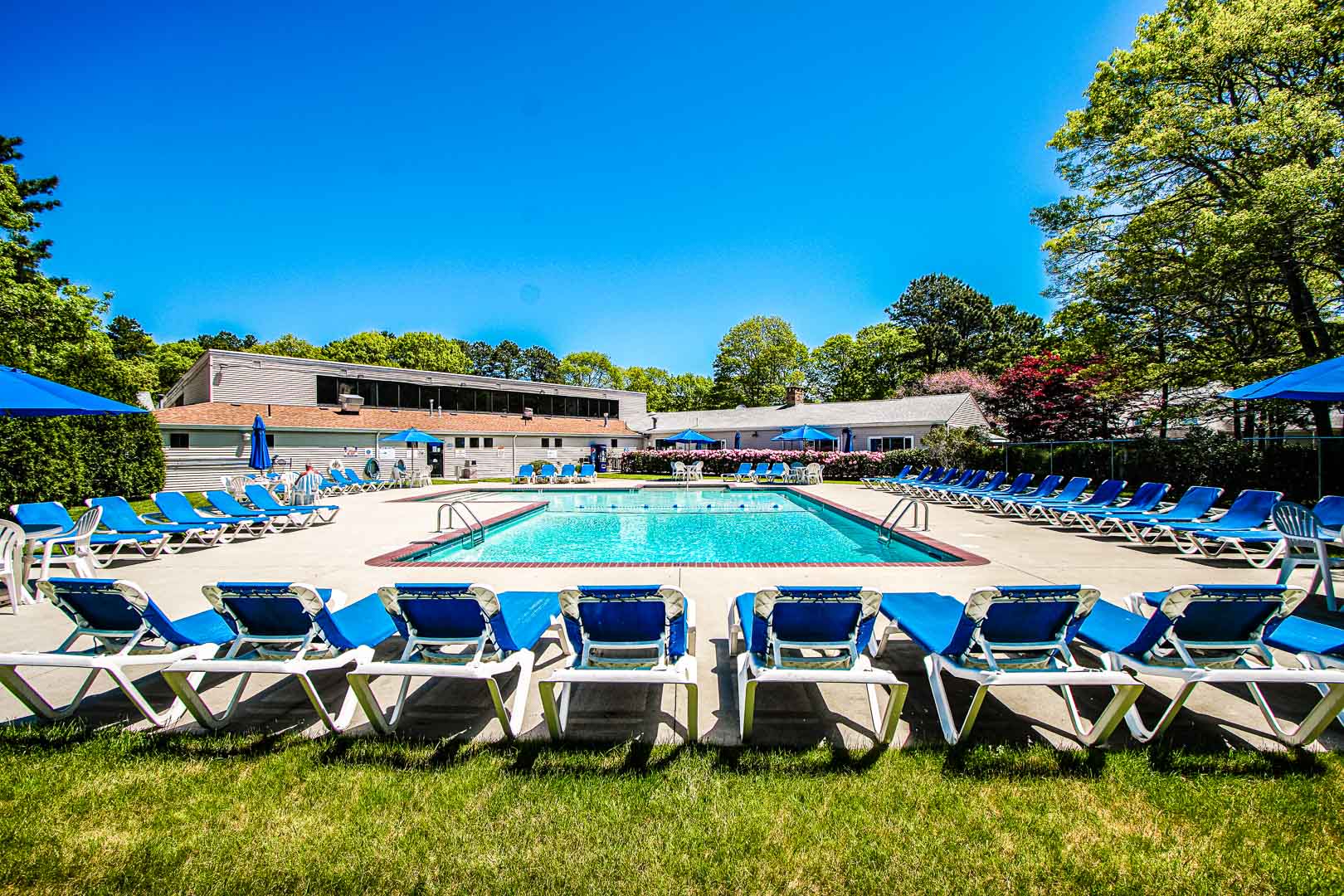 An expansive view of the outdoor swimming pool and lounging chairs at VRI's Sea Mist Resort in Massachusetts.